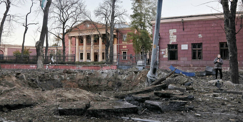 Der Krater einer russischen Rakete ist auf der Straße zu sehen, im Hintergrund das Museum mit seinem klassischen Säulen-Eingang