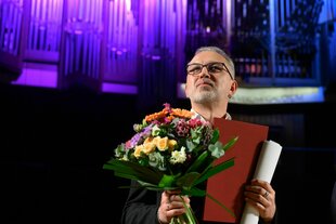 Alhierd Bacharevič mit einem Blumenstrauß am Mittwochabend in Leipzig