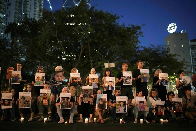 Israelische Aktivisiten haben sich in zwei Reihen positioniert und zeigen Fotos von getöteten Kindern aus Gaza